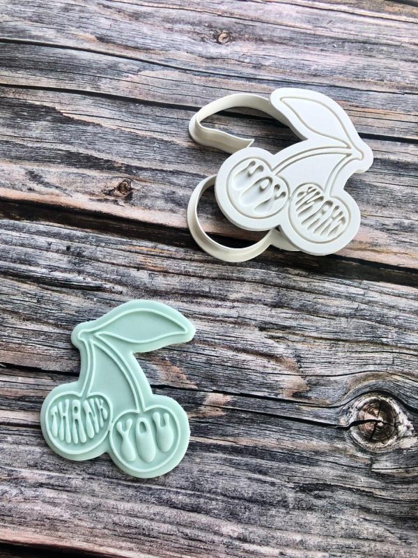 Thank you cherry cookie cutter and fondant stamp with cherries and thank you message on wooden background