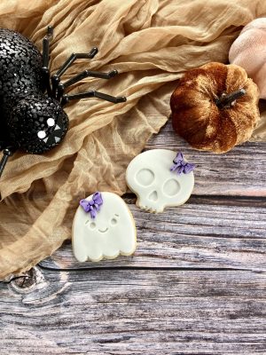 Skull and ghost cookie cutter and fondant stamp set displayed on a Halloween-themed plate, 3D-printed from biodegradable food-safe PLA