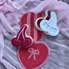 Cherry Cookie Cutter and Fondant Embosser Red heart-shaped cookie with double cherry cookie cutter and fondant embosser on a pink cloth, Valentine design