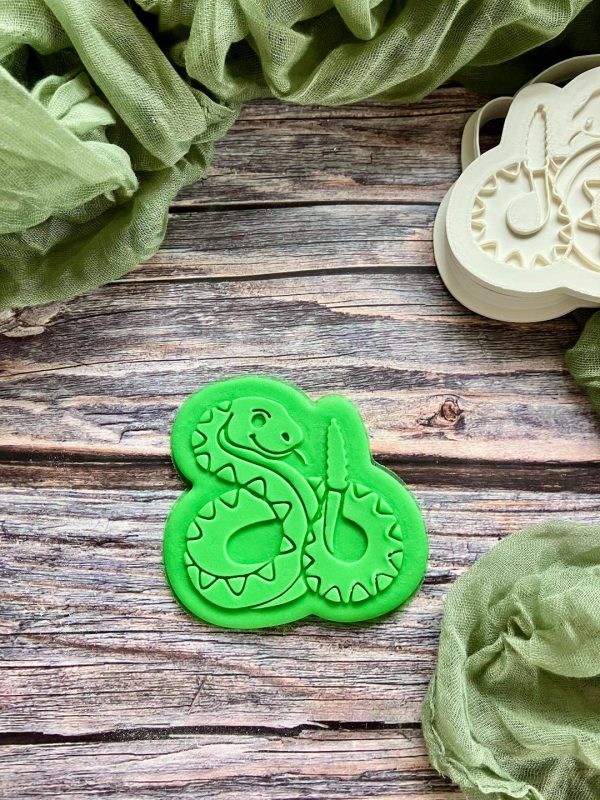 Snake cookie cutter and fondant embosser set displayed on a green plate, 3D-printed from biodegradable food-safe PLA