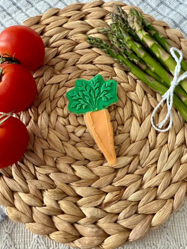 Carrot cookie cutter & embosser with green top on mat
