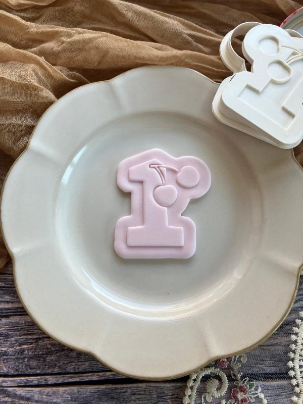 Cherry number one cookie cutter and fondant embosser on beige plate