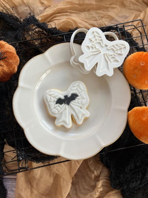 Halloween Bow Cookie Cutter β Bat & Spiderweb Embosser (8cm) 8cm bow-shaped cookie cutter and fondant embosser with bat and spiderweb design
