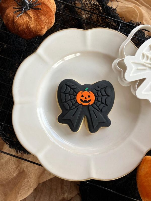 Pumpkin & Spiderweb Bow Cookie Cutter โ Halloween Embosser (8cm) 8cm bow-shaped cookie cutter and fondant embosser with pumpkin centre and spiderweb pattern